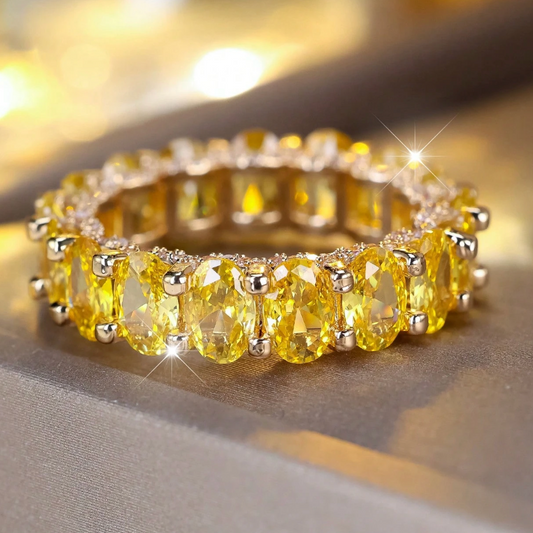 Gold bracelet with yellow gemstones on a reflective surface