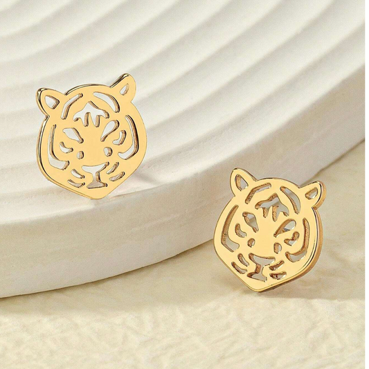 Gold tiger head earrings on a beige background