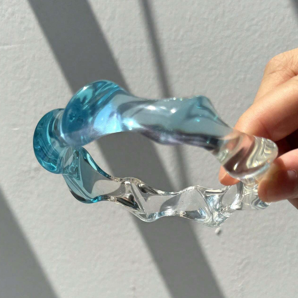 Clear and blue plastic tool held by a hand on a light gray background
